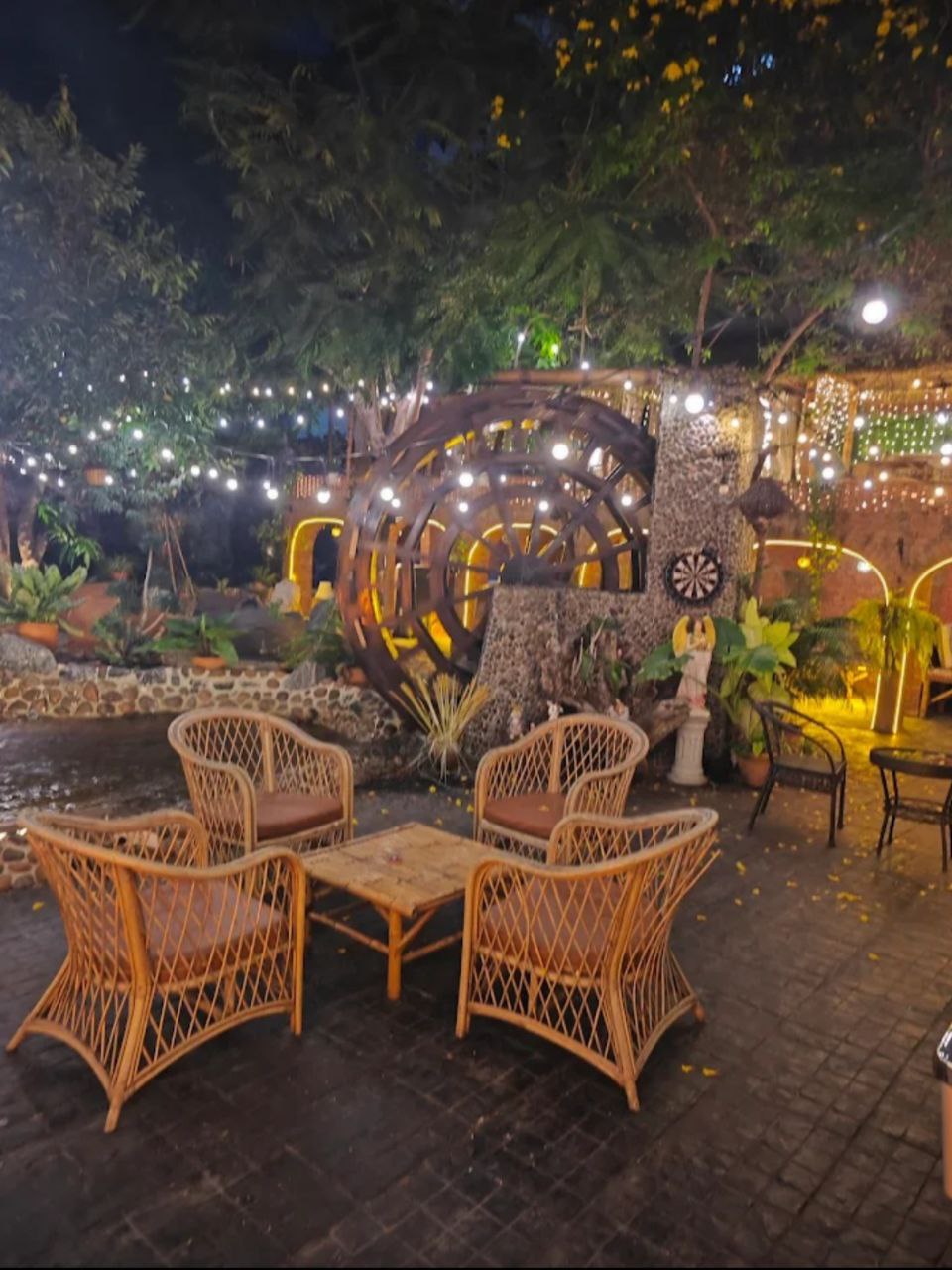 Authentic garden atmosphere with rattan chairs and warm string lights at night